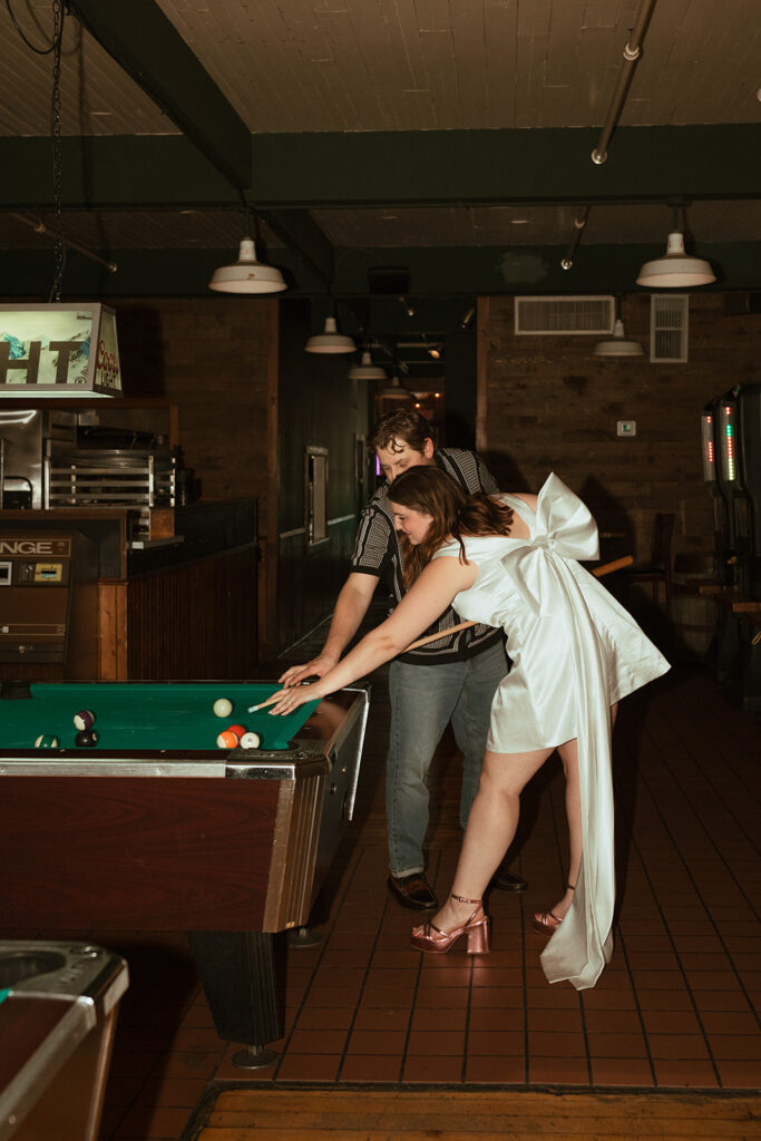 couple playing pool outside Minneapolis in Stillwater, Minnesota for their engagement photos