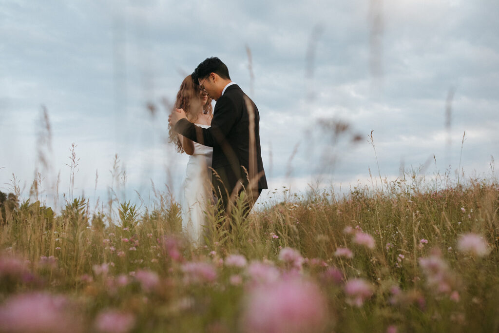 A couple dances in a field of flowers in a minnesota elopement session 