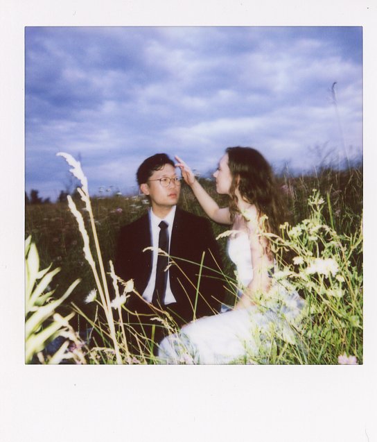 Instant film shows a couple in a field for a minnesota elopement inspired anniversary photoshoot