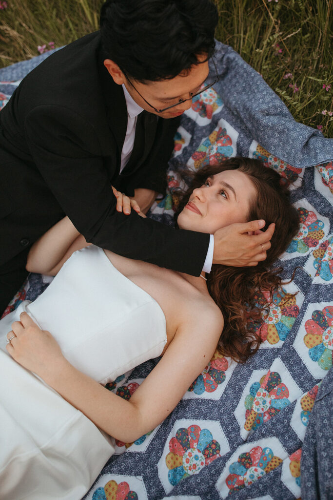 A  couple is photographed on a quilt by a Minnesota elopement photographer 