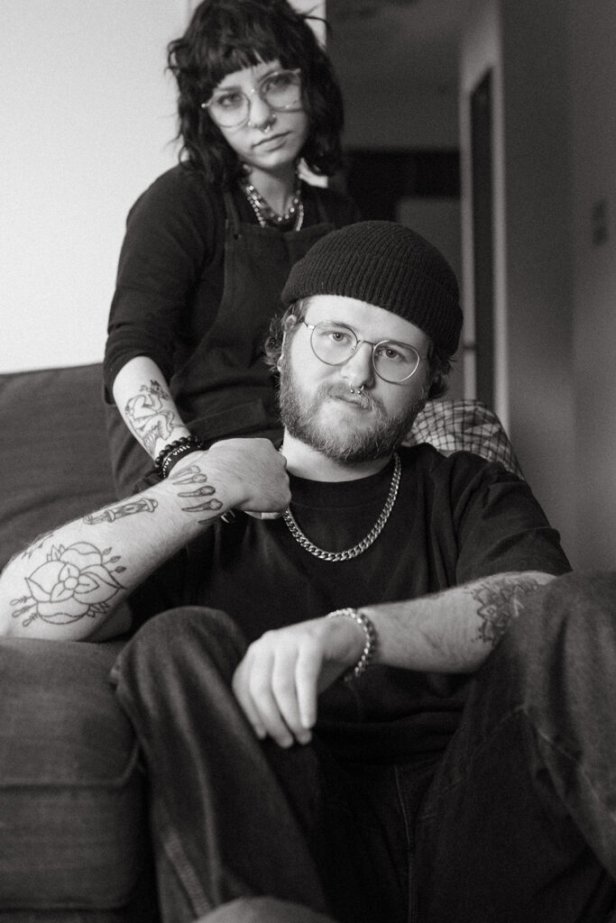 A young man holds the hand of his fiancee in their living room during engagement photos in Milwaukee, WI. 