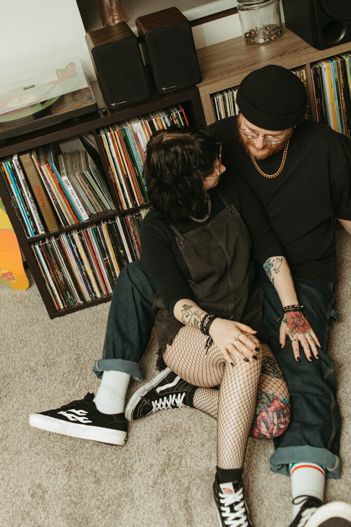 A Wisconsin couple lean against their vinyl collection during engagement photos with a Wisconsin photographer. 