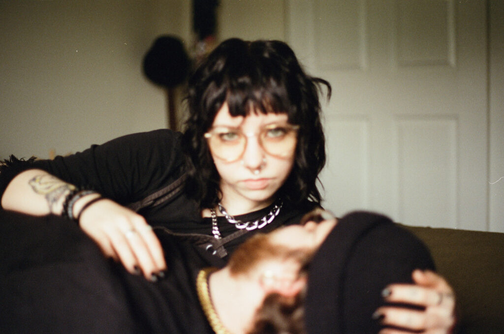 A film photo of a young woman snuggling with her fiance taken during engagement photos in Milwaukee, WI. 