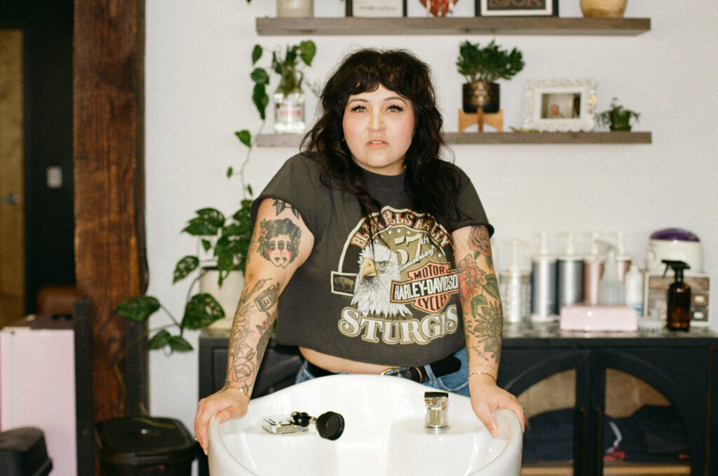 Lady Luck Salon owner leans over a shampoo bowl during a brand session with a Wisconsin photographer for creative brands. 
