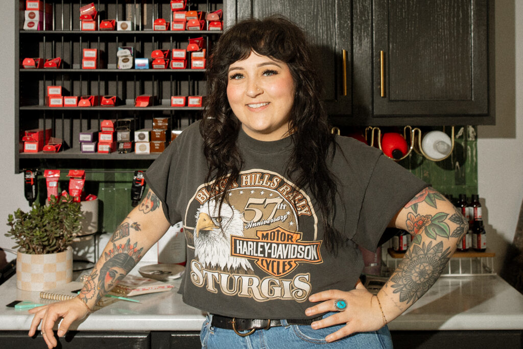 A Milwaukee salon owner smiles as she leans against a counter during a milwaukee photography session with a brand photographer. 