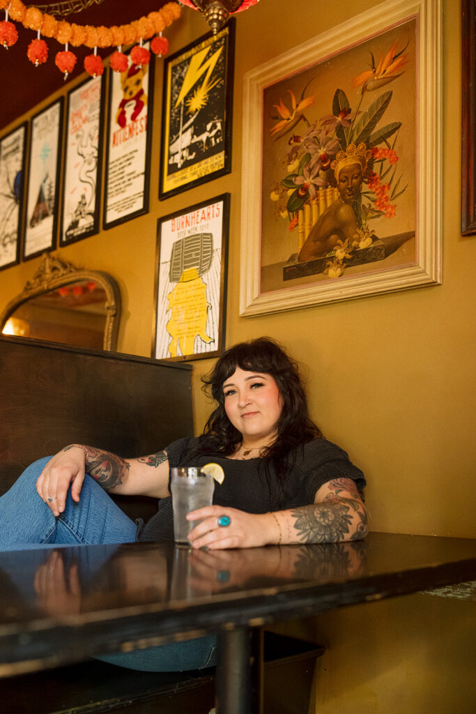 A hairstylist poses in a booth at Burnhearts Milwaukee during a personal branding photoshoot. 