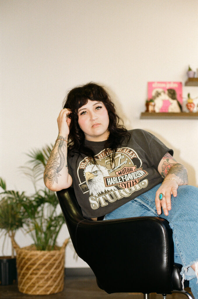 Allie of Lady Luck Salon in Milwaukee is seated in a salon chair during a brand session with Wisconsin photographer for creative brands. 