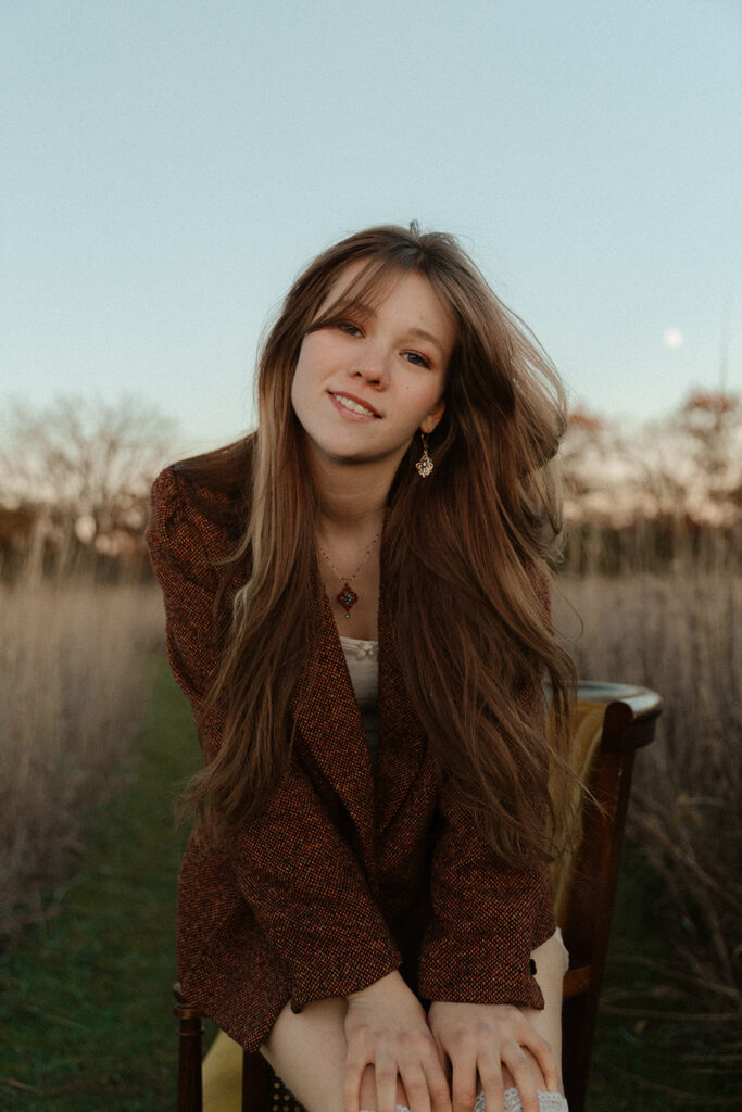 A young woman wearing a vintage blazer poses in a photo taken by a Minnesota senior photographer. 