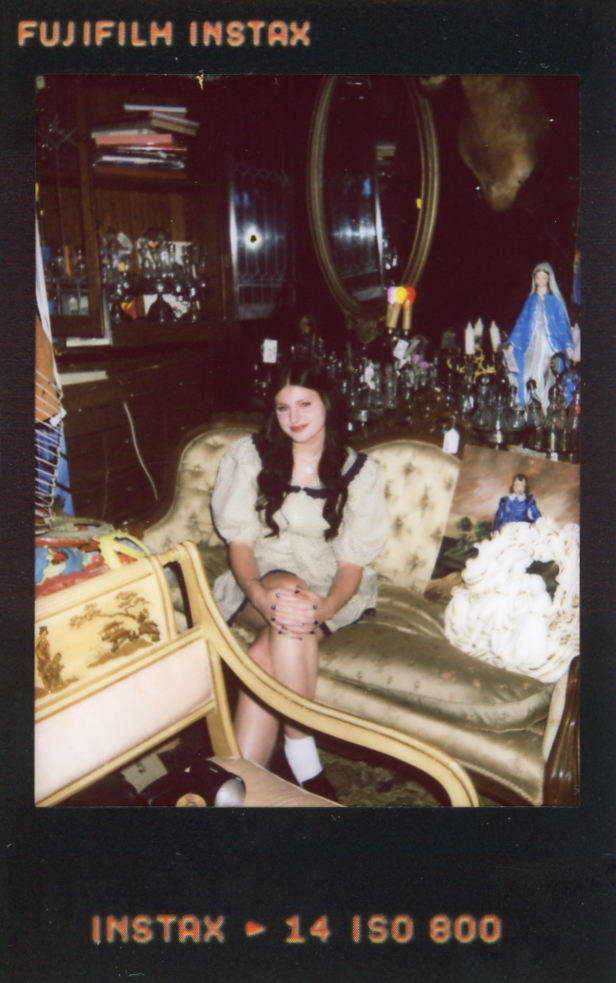 An instax film photo shows a small piece of senior pictures in Minneapolis taken at Hunt & Gather Antiques.