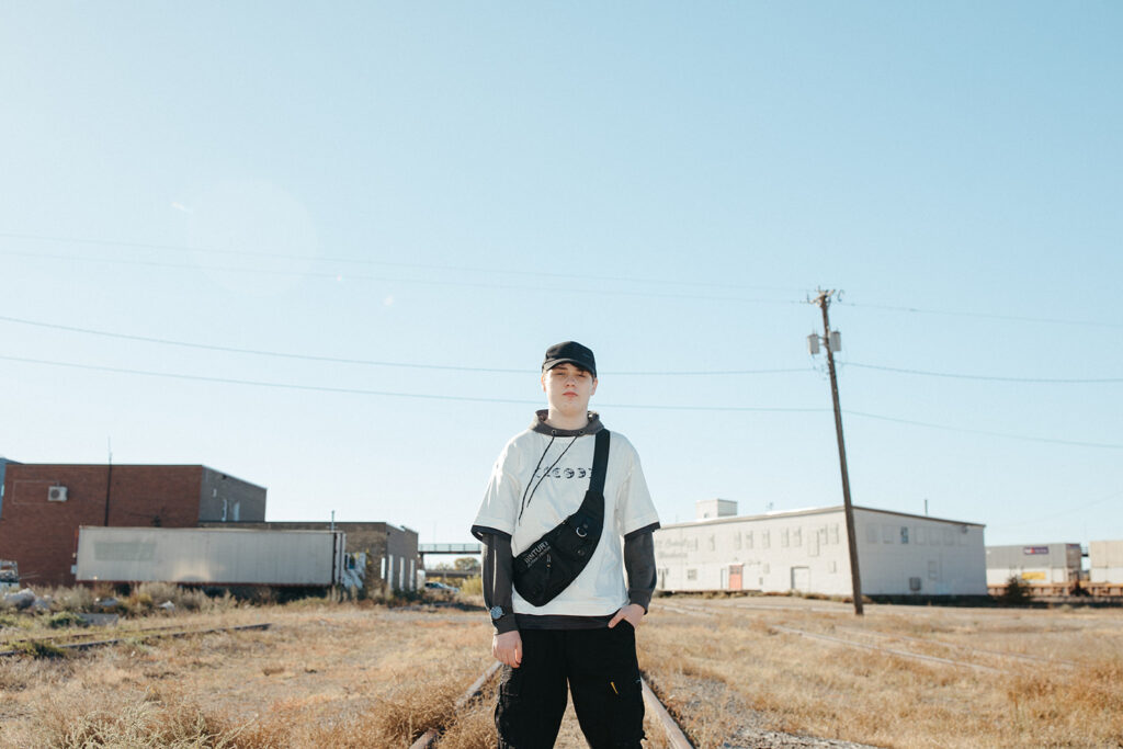 A high school senior is photographed midday on his walk home during senior pictures twin cities. 